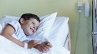 Enfant souriant dans un lit d'hôpital