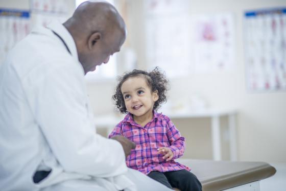 un médecin examine une enfant souriante dans une clinique médicale
