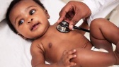 Un bébé se fait examiner par un médecin.