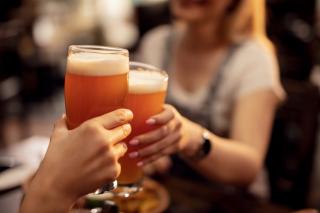Un homme et une femme trinquent avec une bière.