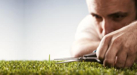 Homme taillant la pelouse avec des ciseaux