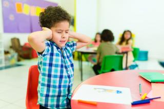 Un autiste est affecté par le bruit dans sa classe à l'école.